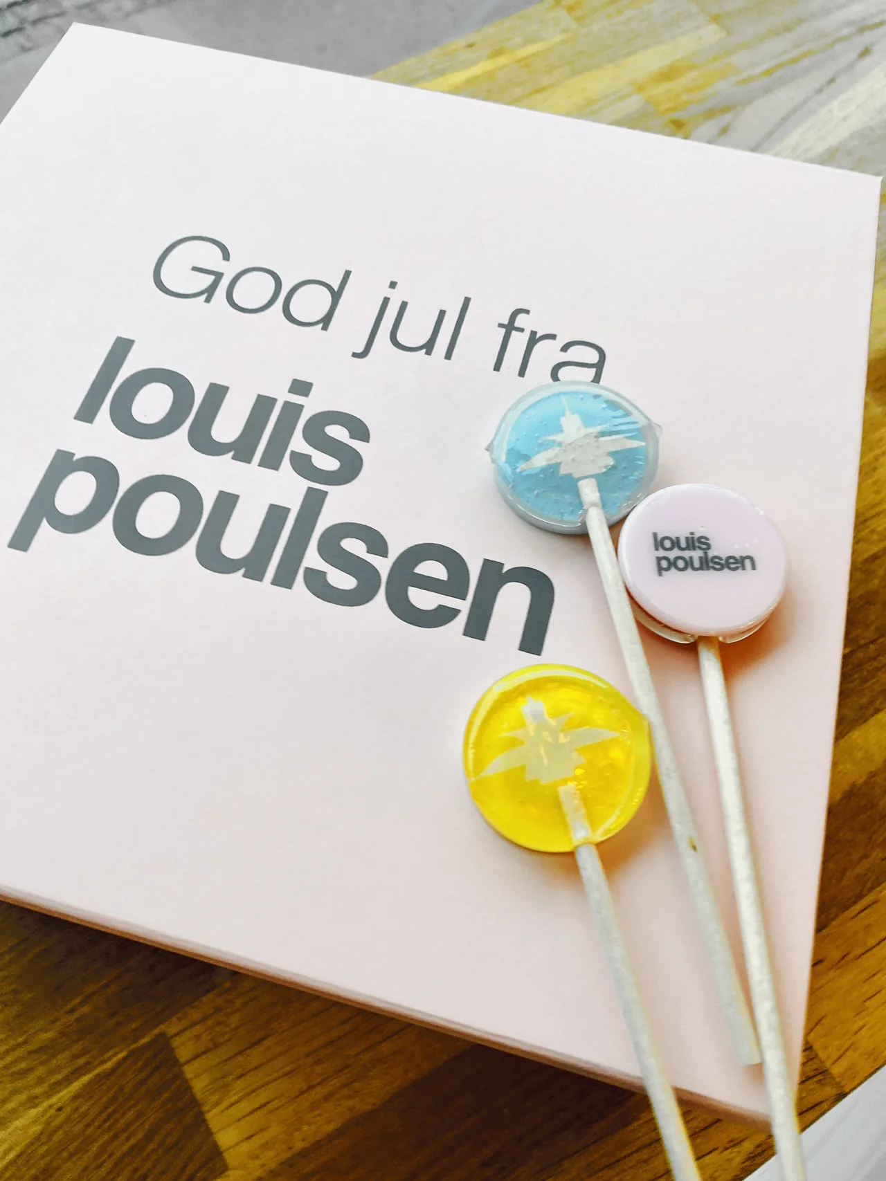 Slikkepinde med Louis Poulsen-logo og motiv sammen med en personlig julehilsen
